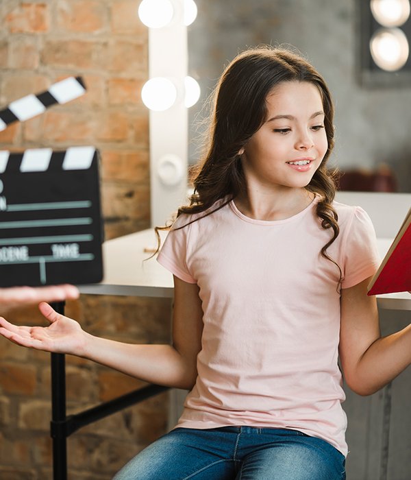 person-holding-clapperboard-front-girl-rehearsing-backstage